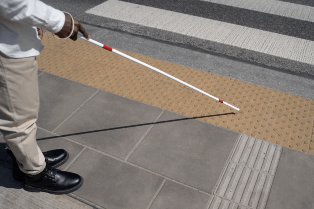 Blind person uses tactile floor marks for orientation.